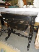 A Victorian ebonised games and sewing table.