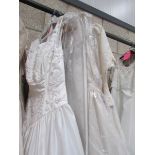 Approximately 10 wedding gowns in various sizes.