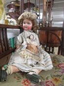 A bisque headed doll marked SH, PB in star, 1909 - 7, Germany and a smaller doll.