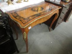 A marquetry centre table with black panels.