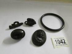 A Whitby jet bangle, plaque, mourning locket and 2 brooches.