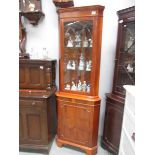 A golden mahogany corner cabinet.