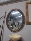 An oval framed mirror.