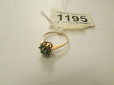 A 18ct gold cluster ring set 7 emeralds, size M half.