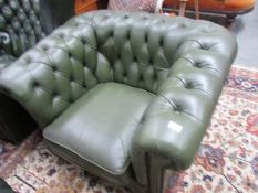 A green leather Chesterfield chair.