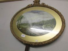 An oval gilt framed oil on board rural scene.