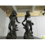 A pair of heavy cast metal cherub figures.