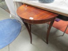 A mahogany D shaped table.