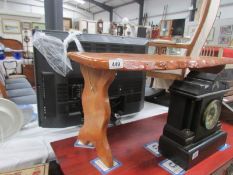 A polished wood table with folding legs.