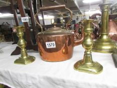 A copper kettle and a pair of brass candlesticks.