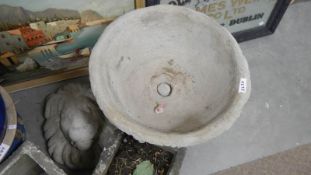 A modern large garden pot on base and a lions head.