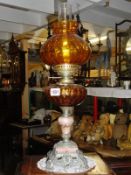 A spelter and marble oil lamp with amber glass font and shade.