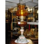 A spelter and marble oil lamp with amber glass font and shade.