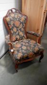 A wood framed armchair with floral upholstery