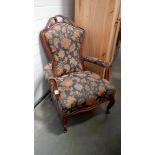 A wood framed armchair with floral upholstery