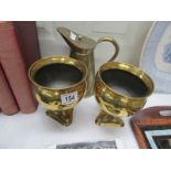 An arts and crafts embossed jug together with a pair of brass planters with dolphin supports.