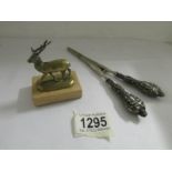 A miniature model of a deer on marble base and a pair of silver handled glove stretchers.