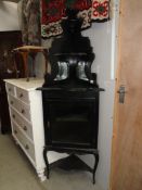 An ebonised corner cabinet.