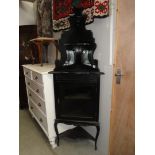 An ebonised corner cabinet.