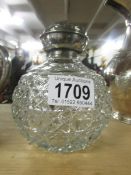 A silver topped scent bottle.