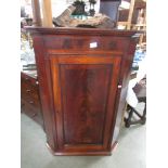 A mahogany corner cupboard.