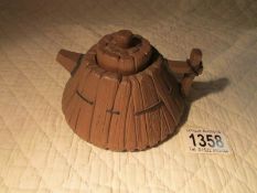 An oriental terracotta teapot, signed to base and under lid.