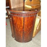 A mahogany corner cupboard.