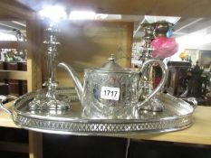 A silver plate tray, pair of candlesticks and tea pot.