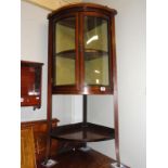 An Edwardian mahogany corner cabinet on splay legs.