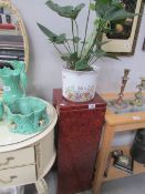 A marble effect pedestal and a potted plant.