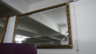 An oblong gilt framed mirror.