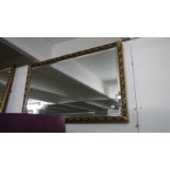 An oblong gilt framed mirror.