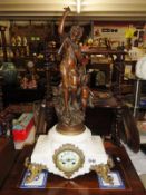 A Victorian marble and gilded mantel clock with four pillars and surmounted by figure.