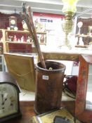 A leather stick stand and 3 walking sticks.