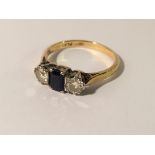 An 18ct gold ring set central sapphire and 2 shoulder diamonds, size N.