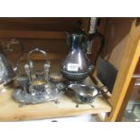 A silver plate water jug, egg cup stand and cream jug.