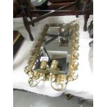 A brass framed wall mirror with candle sconces.