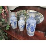 A pair of blue and white vases and one other.