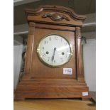 An Edwardian oak cased mantel clock with Westminster chime including key and pendulum,
