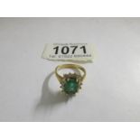 An 18ct gold ring set diamonds and central emerald.