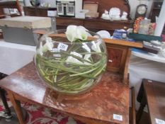 A large glass bowl decorated with arum lilies,.
