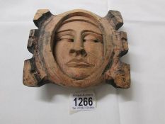 A boxwood carving of a face mask.