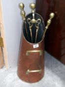 A copper coal scuttle with a set of brass fire irons