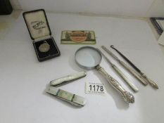A mixed lot including button hooks, pen knives, magnifying glass etc (some silver).