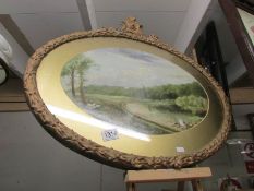 An oval gilt framed and glazed watercolour rural scene.