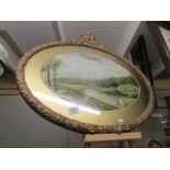 An oval gilt framed and glazed watercolour rural scene.