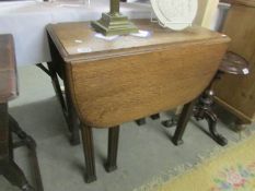 An oak gate leg table on square reeded legs.