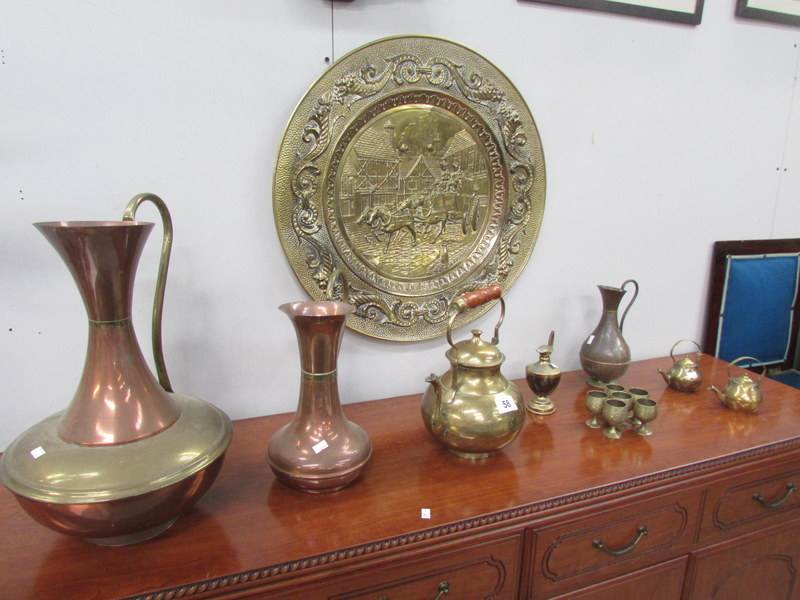 A large brass plaque, copper jugs, brass teapot, 6 brass goblets etc.