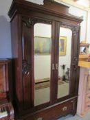 An Edwardian mahogany double wardrobe with bevelled mirror doors.