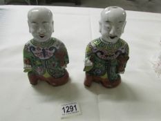A pair of early 19th century Chinese pottery laughing boys (He-He boys) a/f.